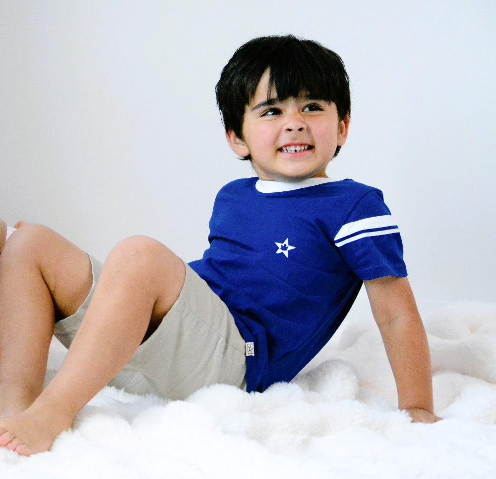 Child wearing a blue shirt organic cotton with a star design, Canadian